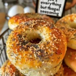 Four homemade everything bagels on a blue plate.